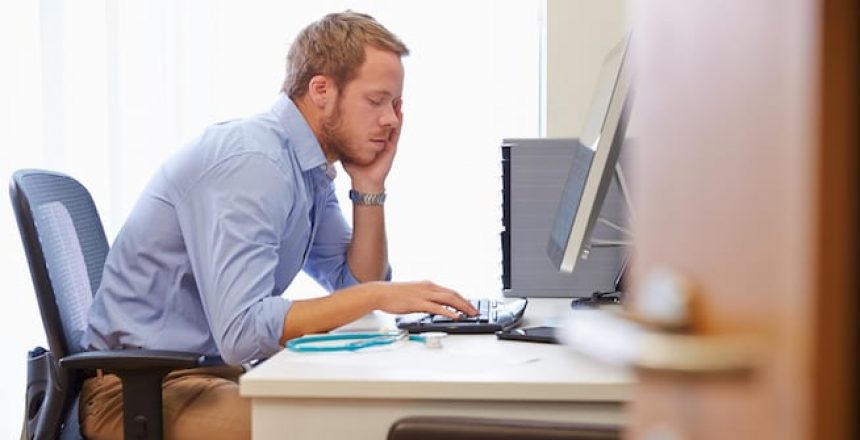 Overworked Man Sitting at Computer